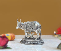 Brass cow with calf figurine, side view, ornate panel detailing