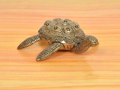 Brass tortoise figurine, side view with detailed legs and patterned shell