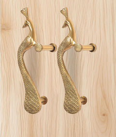 Golden brass peacock door handle pair with curved bodies and cylindrical lever grips