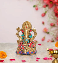 Gold-toned Ganesha idol statue with red and turquoise jeweled detailing, on base