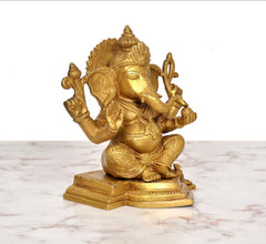 Brass sitting Lord Ganesha statue, golden finish, arms posed, angled view