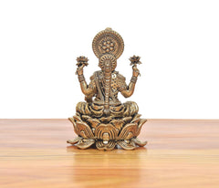 Front view of Lakshmi bronze murti seated on lotus, detailed chest ornaments and crown