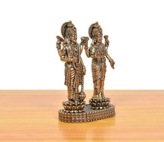 Brass Lakshmi and Vishnu figurines standing on round ornate base