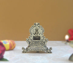 Brass Lakshmi oil lamp diya showing rear filigree and raised crown, side angle