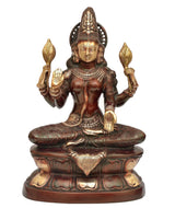 Seated Lakshmi statue in dark brass with gold-toned lotus pedestal, front view