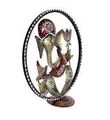 Iron Ganesha idol in oval circular frame, red outfit, gold patterns, feet on round stand