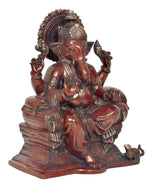 Ganesha brass idol seated on base, raised hands in blessing pose, maroon-bronze finish