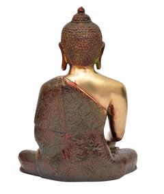 Back view of brass Buddha statue with dark patterned robe and seated lotus base