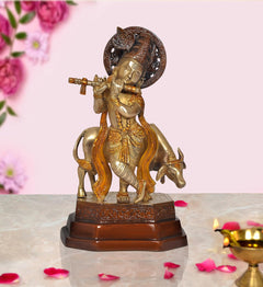 Brass Krishna idol standing on cow, playing flute, with ornate circular halo base