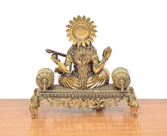 Saraswati brass idol from back, sun halo above head, veena and hands raised