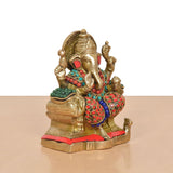 Brass Ganesha seated figure, side angle, teal-and-red jewelry details, gold trim