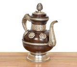 Himalayan brass teapot with curved spout, embossed body motifs, and tall finial lid