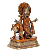 Lord Krishna and cow brass figurine, angled view on ornate pedestal