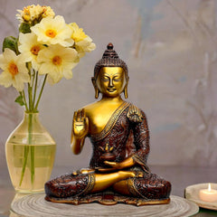 Seated brass Buddha idol with blessing hand raised, golden face, detailed maroon robe