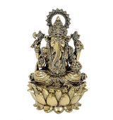 Brass Ganesh idol seated on a lotus base with ornate crown and jewelry