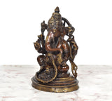 Brass Ganpati Bappa murti, left profile of seated four-armed deity with halo