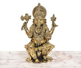 Front view of Lord Ganesha idol, seated posture with crown, garlands, and raised arms