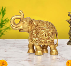 Brass elephant figurine with carved patterned body and raised trunk, front view