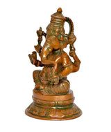 Brass Ganesha idol in side view, detailed face, trunk, and jeweled headgear