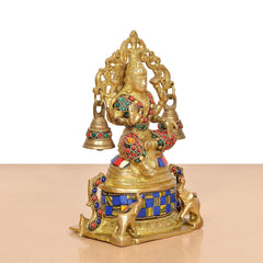 Brass Lakshmi statue angled view with blue-gold base pattern, bells, and multicolor ornaments