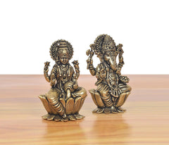 Three-quarter view of bronze Lakshmi and Ganesha mini statues seated on lotus bases.