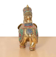 Standing view brass king on elephant statue with gold body and colorful patterned saddle