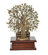 Brass Tara Devi statue details: ornate tree trunk and canopy on wooden base
