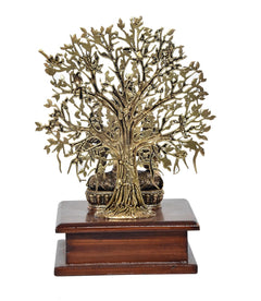 Brass Tara Devi statue details: ornate tree trunk and canopy on wooden base