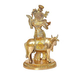 Brass khaniya statue: cow and flute-playing figure, flute raised, decorative patterns