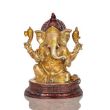 Brass Ganesha statue idol with detailed crown and red accents on round base