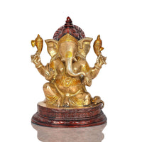 Brass Ganesha statue idol with detailed crown and red accents on round base
