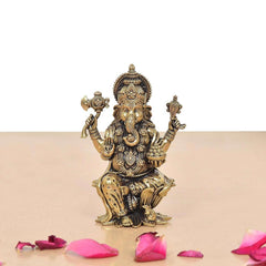 Brass Lord Ganesha statue with raised hands, detailed jewelry, and seated posture.