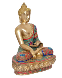 Brass meditating Buddha idol, three-quarter side view, gold face, teal red mosaic robe