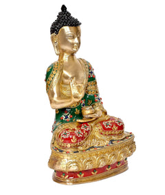 Gold brass meditating Buddha statue, profile view, green robe with red floral details