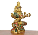Brass Saraswati idol kneeling, jeweled ornaments, arms posed with veena