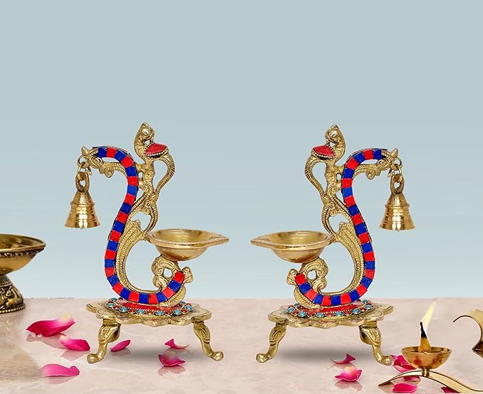 Brass bird peacock diya stand pair with blue-red beaded serpent, two oil bowls and bells