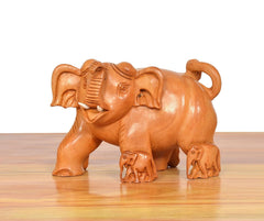 Wooden elephant showpiece in side view, brown carved details on trunk and feet
