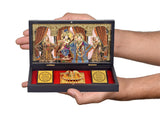 Hands holding gold-plated Radha Krishna photo frame gift set, open view with deity cards