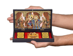 Hands holding gold-plated Radha Krishna photo frame gift set, open view with deity cards