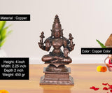 Copper Lakshmi Maa statue with crown and jewelry, seated on a decorated pedestal