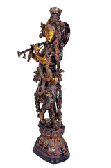 Side view brass Krishna idol with arched halo, detailed jewelry motifs on base