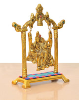 Close-up golden Radha Krishna swing idol on stand with arched frame