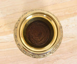 Close-up of bronze kalash interior, showing engraved rim and inner surface