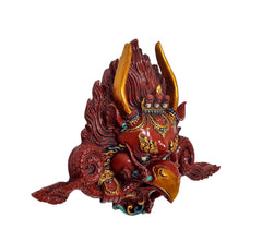 Garuda face wall hanging mask statue angled view, gold horns over red textured hair