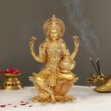 Ornate brass Lakshmi idol statue seated on lotus, hands raised, decorative detailing