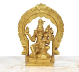 Brass Shiva and Parvati sitting figurine, detailed faces and raised hands within an arch.