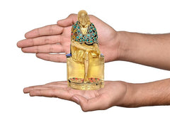 Small brass Shirdi Sai Baba statue idol in hands, front view with jeweled green robe
