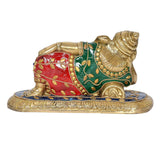 Brass reclining Ganesha statue with red and green painted body, gold base