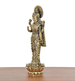 Brass Lakshmi standing idol side view, crowned figure with draped sari on lotus base