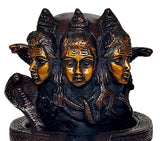 Brass Shiva linga statue close-up of three faces with gold detailing